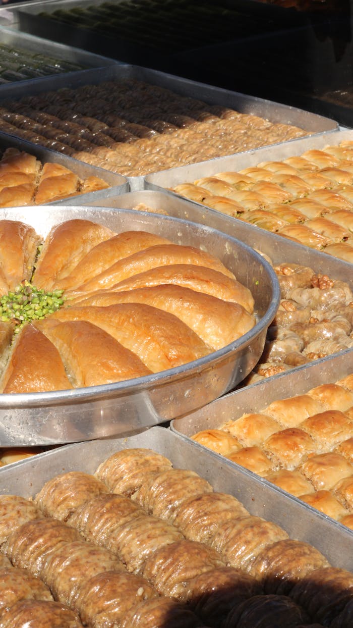 A close-up of assorted trays of Turkish baklava and pastries with a focus on texture and variety.