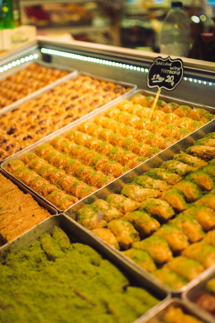 Assorted trays of baklava on display in an Istanbul shop, showcasing Turkish dessert variety.