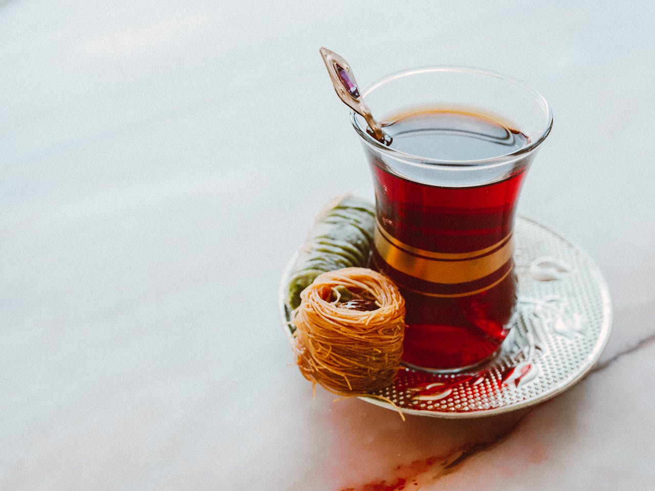 Turkish tea served in a classic glass with baklava, perfect for festive celebrations.