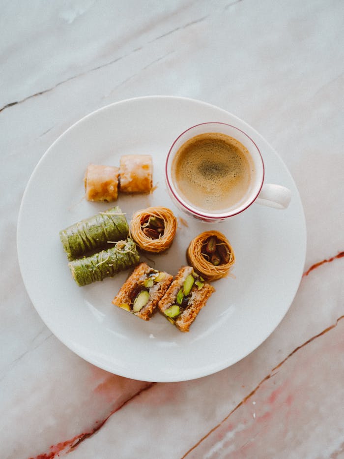 Assorted Turkish pastries paired with espresso against a marble backdrop.