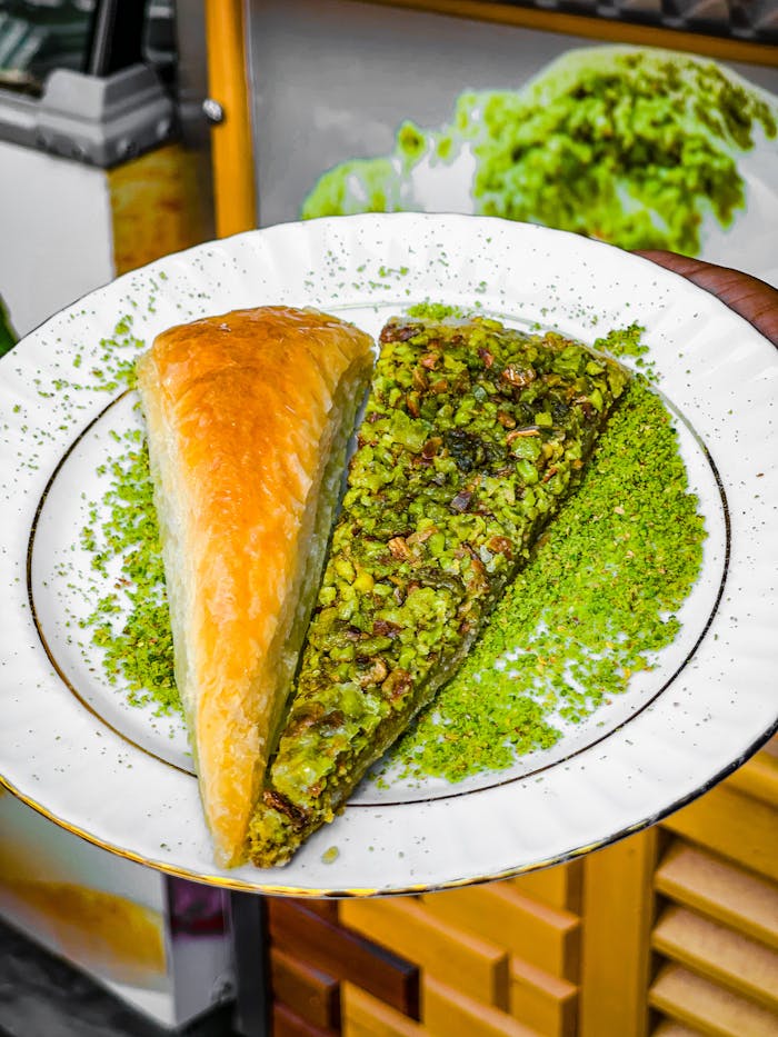 Close-up of delicious pistachio baklava on a white plate, perfect for dessert enthusiasts.